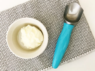 Turquoise ice cream scoop next to small bowl of vanilla ice cream on placemat