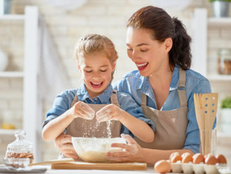 Mother and daughter baking cookies and having fun in the kitchen.