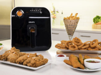 KRUPS Fry Delight air fryer on countertop surrounded by snack foods