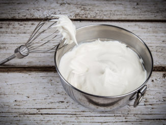 Bowl of whipped cream and whisk