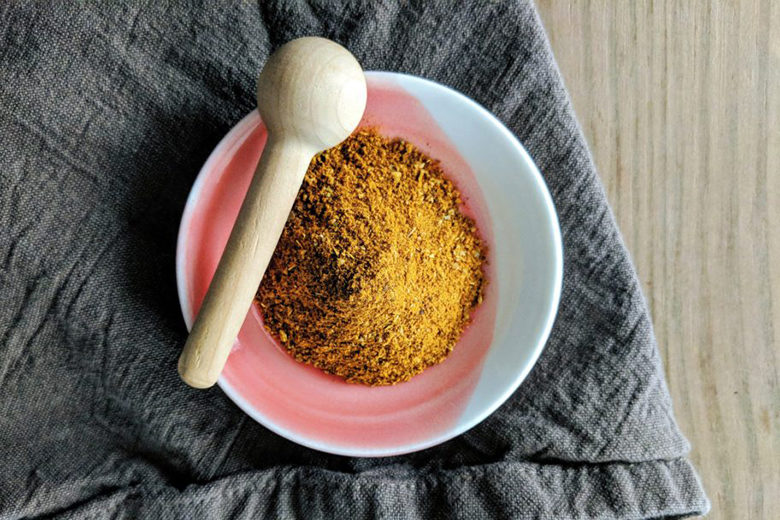 African spice blend Ras el Hanout in a bowl on a gray kitchen towel