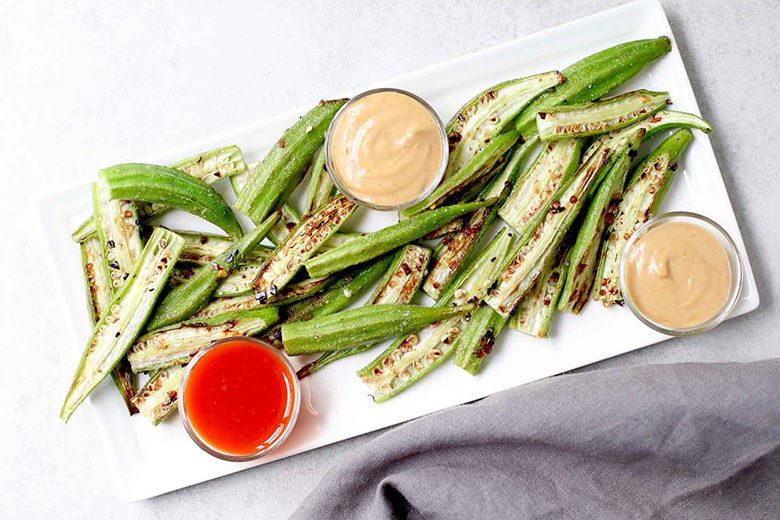 Spicy Roasted Okra with Peanut Sauce on a rectangular white place