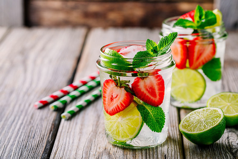 Detox water with strawberry, lime and mint. Ice cold summer cocktail or lemonade in glass mason jar