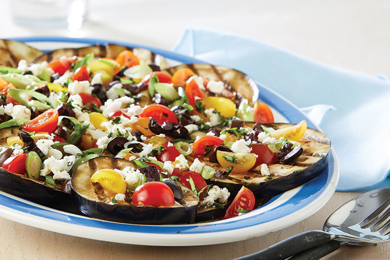 Plate of grilled eggplant with tomatoes and feta