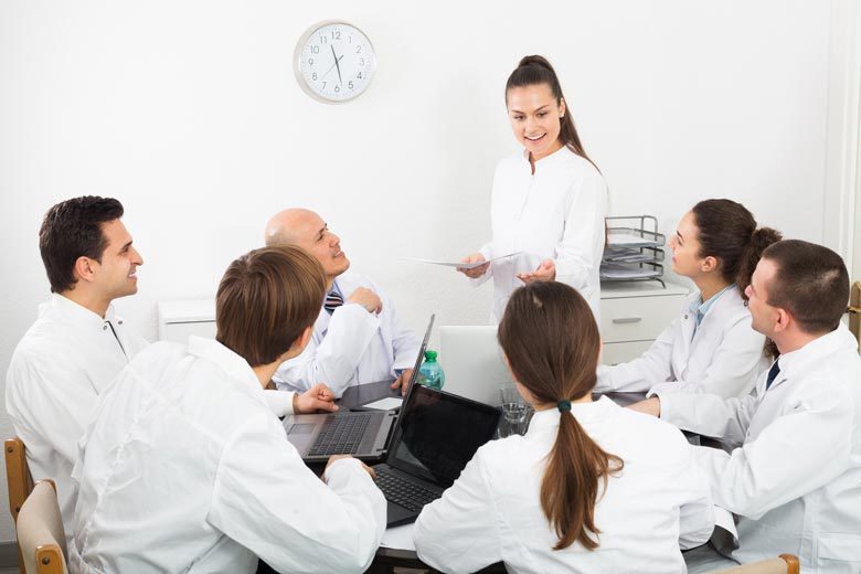 Young woman making presentation in front of colleagues