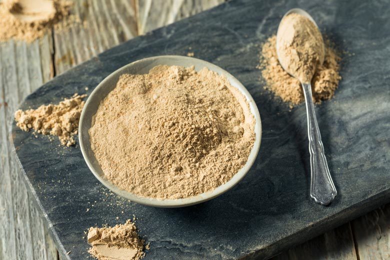 Maca powder in a bowl and a spoon