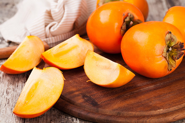 persimmons on wooden background