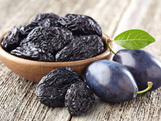 Plum with prunes on a wooden board