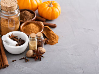 Homemade pumpkin pie spice in a glass jar with ingredients