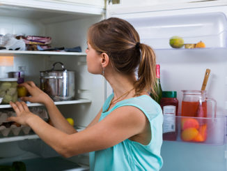 Woman near full fridge